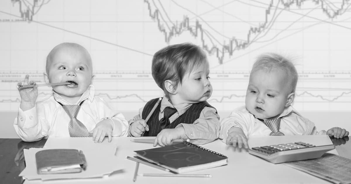 3 toddler boys dressed as financial professionals playing with pencils paper and calculator