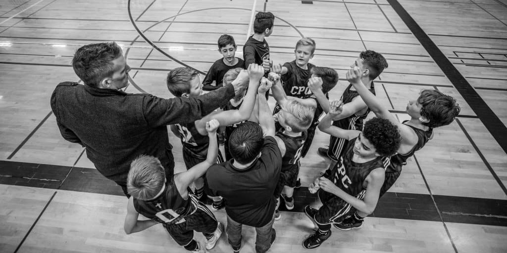 young basketball team and coach in a huddle