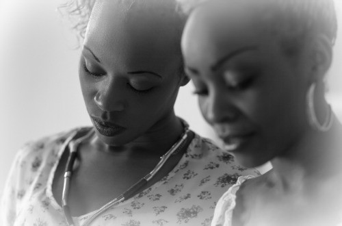 two sisters with their heads pressed together