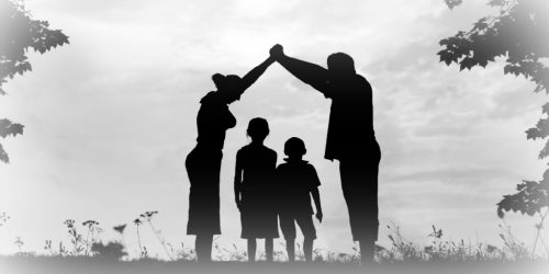 silhouette of a young family of four with parents holding hands above the heads of two children symbolizing an act of protection