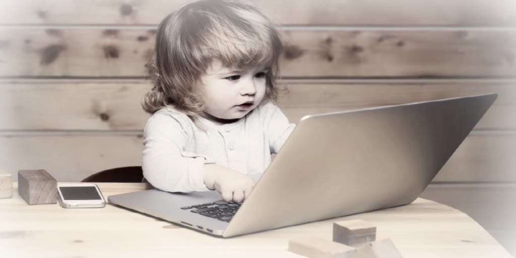 building credit score - young child with her fingers on the keyboard of a laptop computer