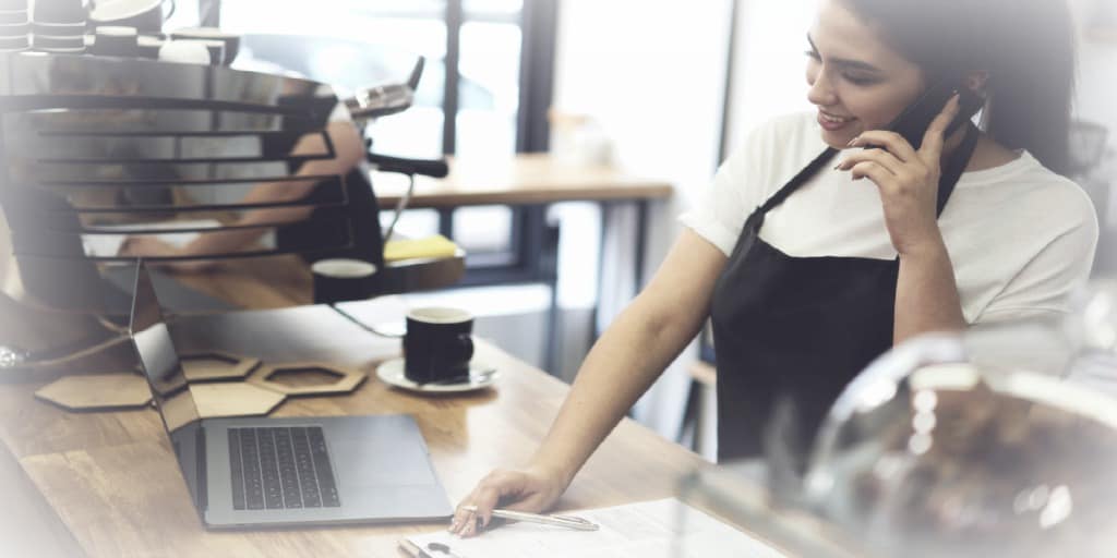 Women on the phone, working in a coffee franchise