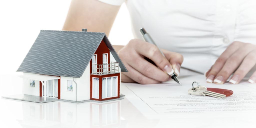 a woman signs a financing contract for buying a home