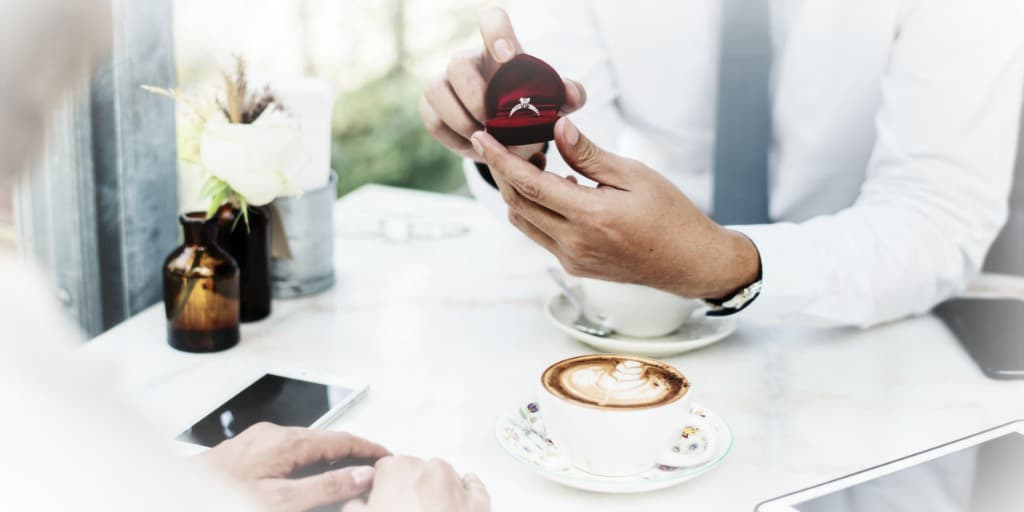 couple discussing their engagement and a prenup over coffee