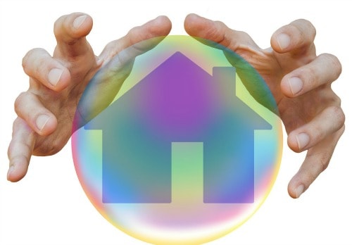 two hands around an illustration of a crystal ball with a house appearing in it