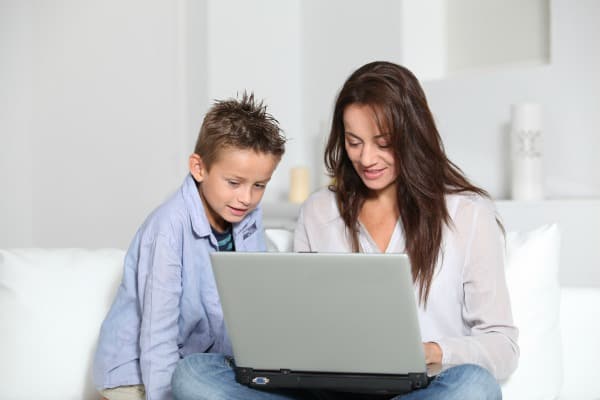 a women and a young boy looking at a laptop computer