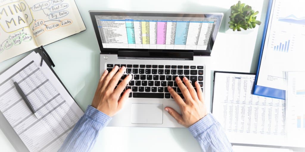 woman working on a spreadsheet on a laptop