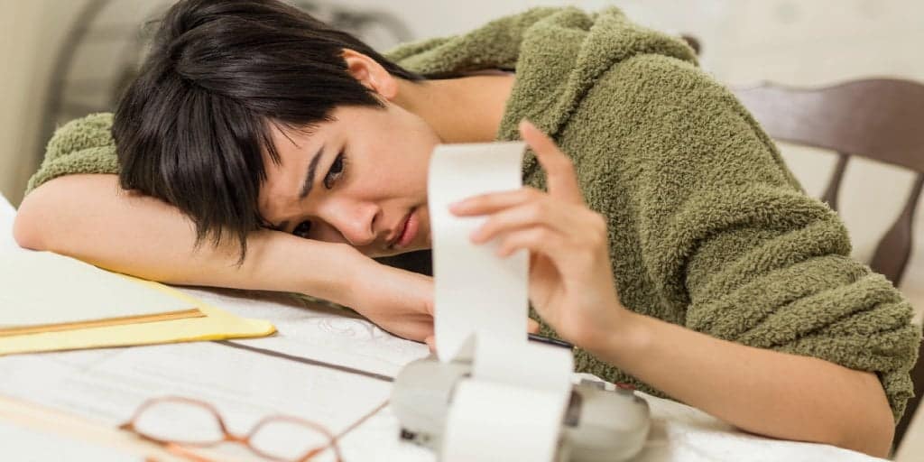 Mixed Race Young Female Agonizing Over Money Troubles at her desk