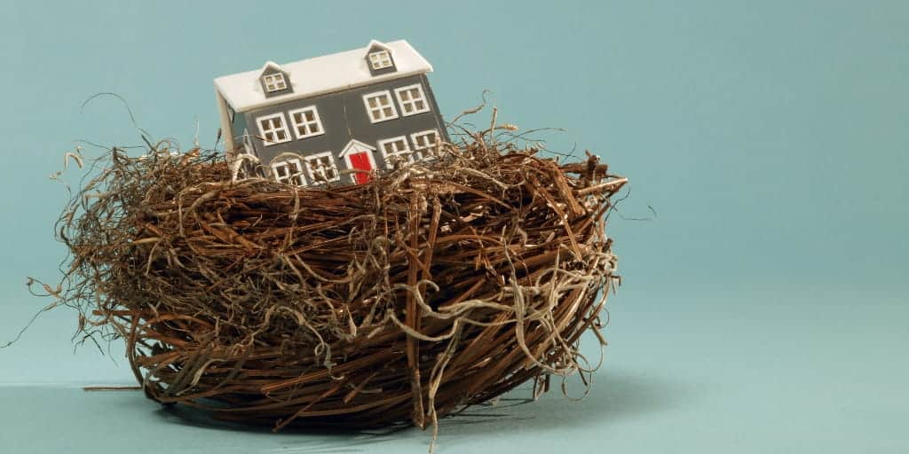 small model of a house sitting in a nest-a reverse mortgage will allow you to tap the nest egg