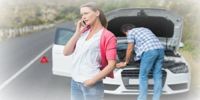 Couple calling roadside service after a car breakdown at the side of the road