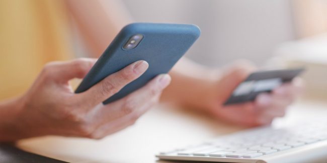 college student using a credit card shopping on smartphone