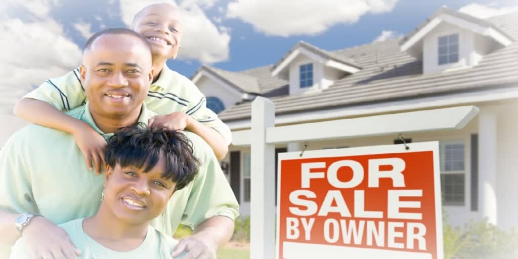 young family in front of a for sale by owner home