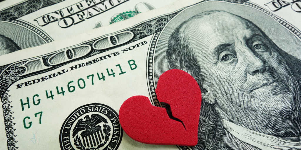 closeup of a broken red heart on cash - divorce concept