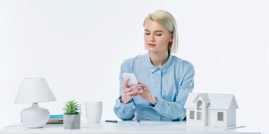 young female real estate agent looking at her smartphone