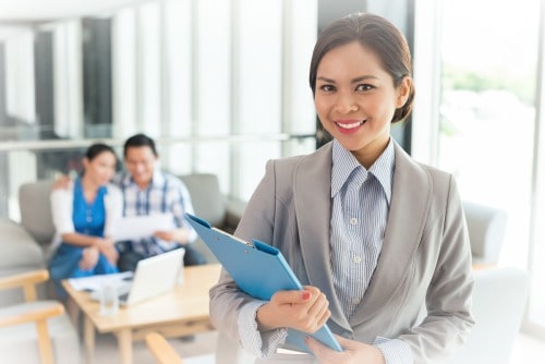 cheerful female real estate agent with a clipboard