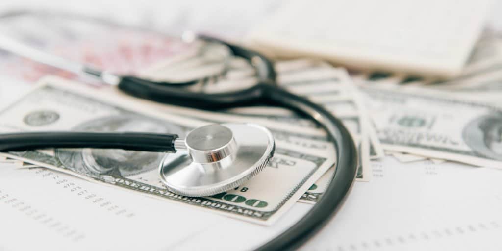 stethoscope on top of cash representing healthcare costs in retirement