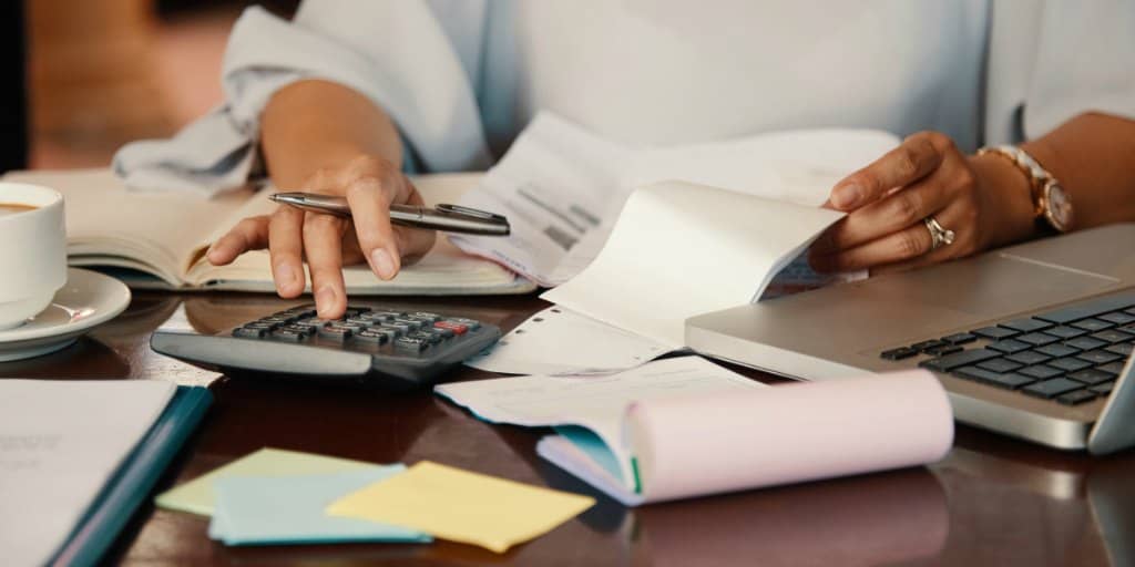 female-reviewing-bills-so-she-can-cut-expenses-and-reduce-spending-to-save-more-money