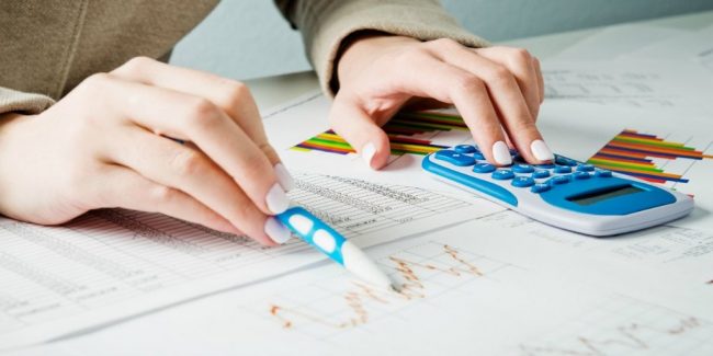 female calculating losses and gains from stock market to see if tax loss harvesting will work for her