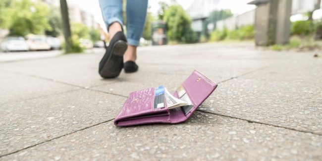 lost womens wallet laying open on a sidewalk