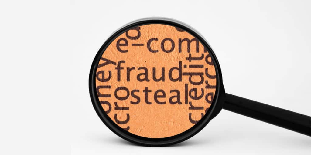 magnifying glass looking at the words fraud, steal, and credit