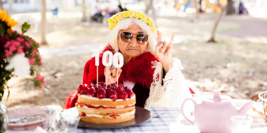 woman celebrating 100th birthday with cake