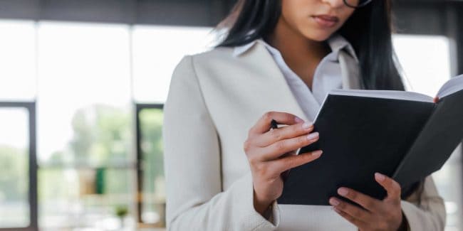 young female entrepreneur reviewing her work in a notebook