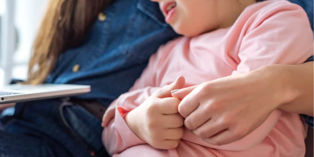 close-up of mother sitting with her special needs daughter