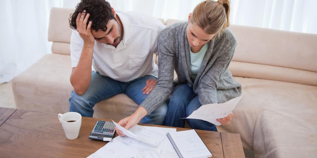 Depressed couple doing their accounting in their living room