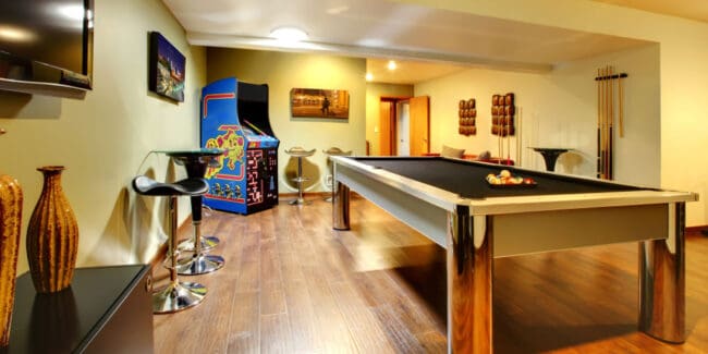 finished basement entertainment area with pool table and pinball machine