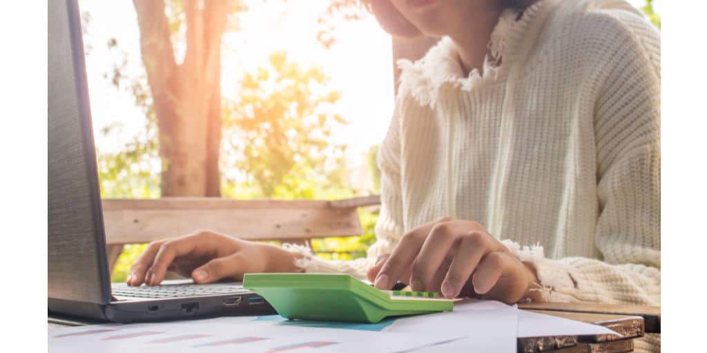 young woman working on laptop and calculator