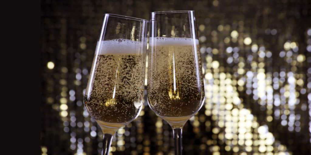 two full champagne flutes toasting new year