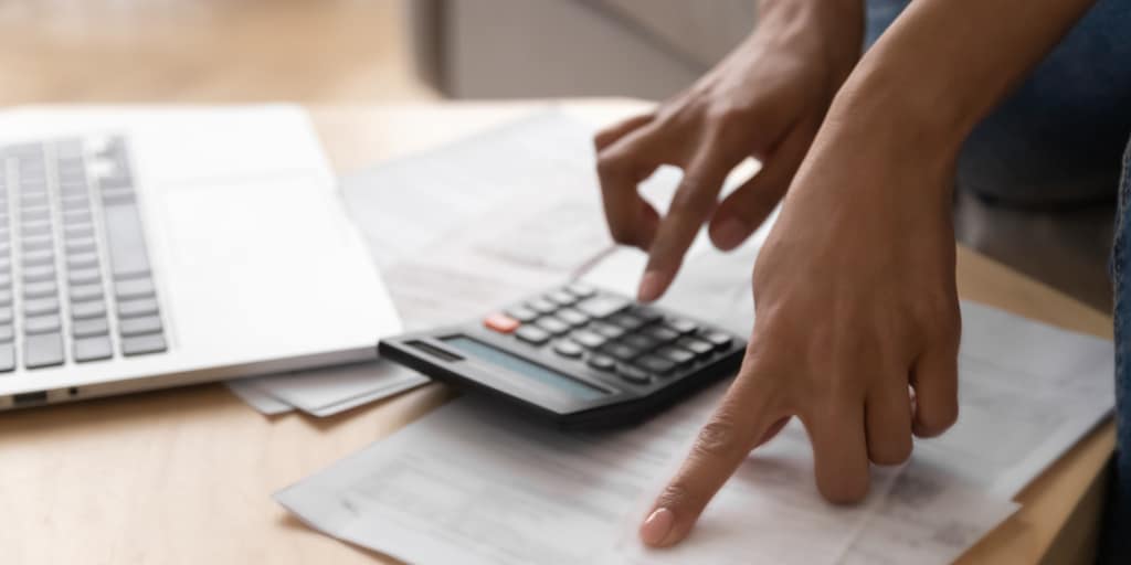 woman using calculator and computer