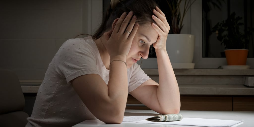 Portrait of stressed woman having few money sitting alone at night.