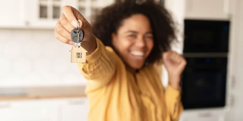 young black woman holding keys to new home purchase