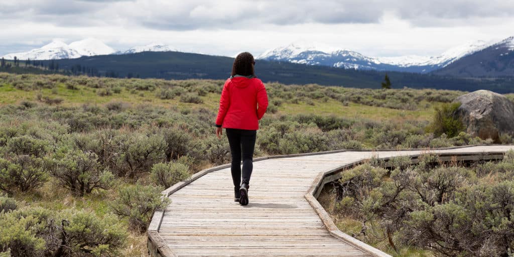 woman adventuring down wooden path in scenic united states national park