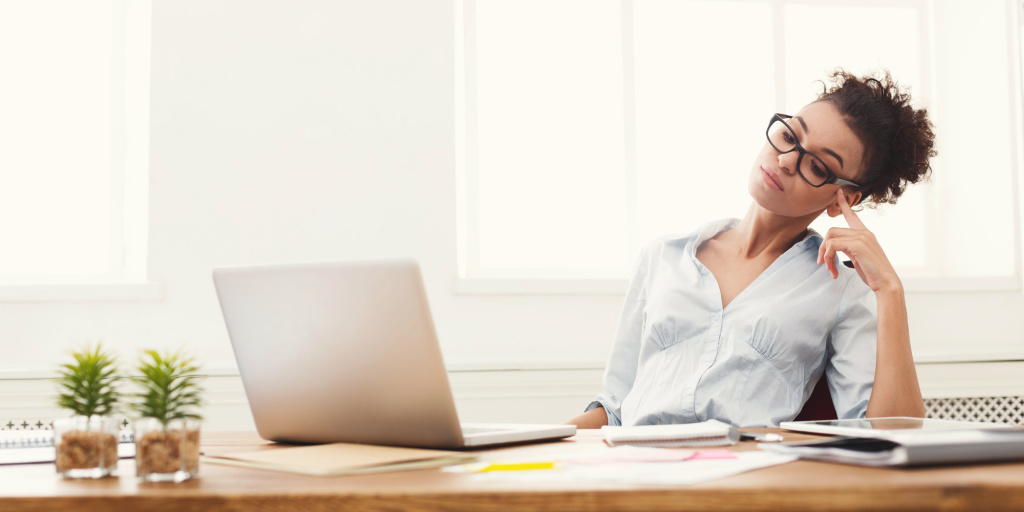 Mujer mirando las finanzas en la computadora portátil en el escritorio